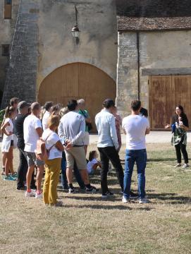 Un groupe de visiteurs suivent une visite guidée dans la cour du château