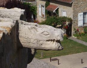 Sculpture d'une gargouille en hauteur à l'entrée du château