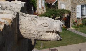 Sculpture d'une gargouille en hauteur à l'entrée du château