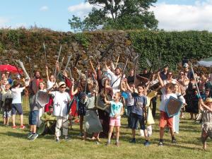 Enfants et adultes avec des armes en mousses pour un tournoi médiéval