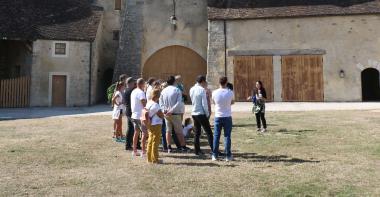 Un groupe de visiteurs suivent une visite guidée dans la cour du château