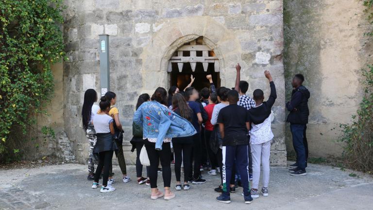 Un groupe de collégiens devant la herse du donjon de Blandy