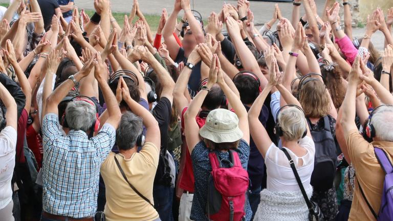 Les visiteurs lèvent les bras lors du final d'une visite décalée avec Magic Meeting