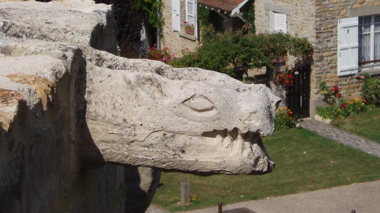 Sculpture d'une gargouille en hauteur à l'entrée du château