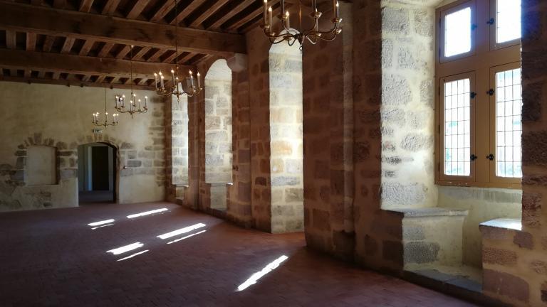 Intérieur de la grande salle du château avec fenêtres et coussièges sur la façade située à droite