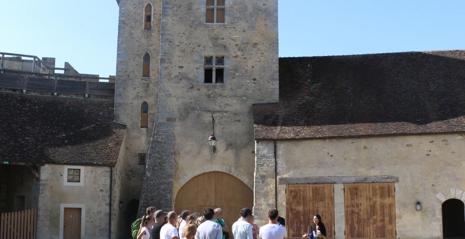 Un groupe de visiteurs suivent une visite guidée dans la cour du château