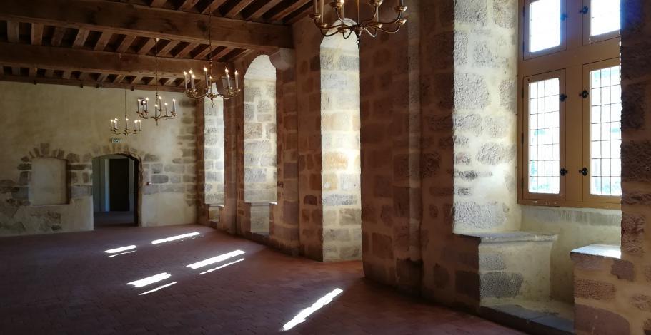 Intérieur de la grande salle du château avec fenêtres et coussièges sur la façade située à droite